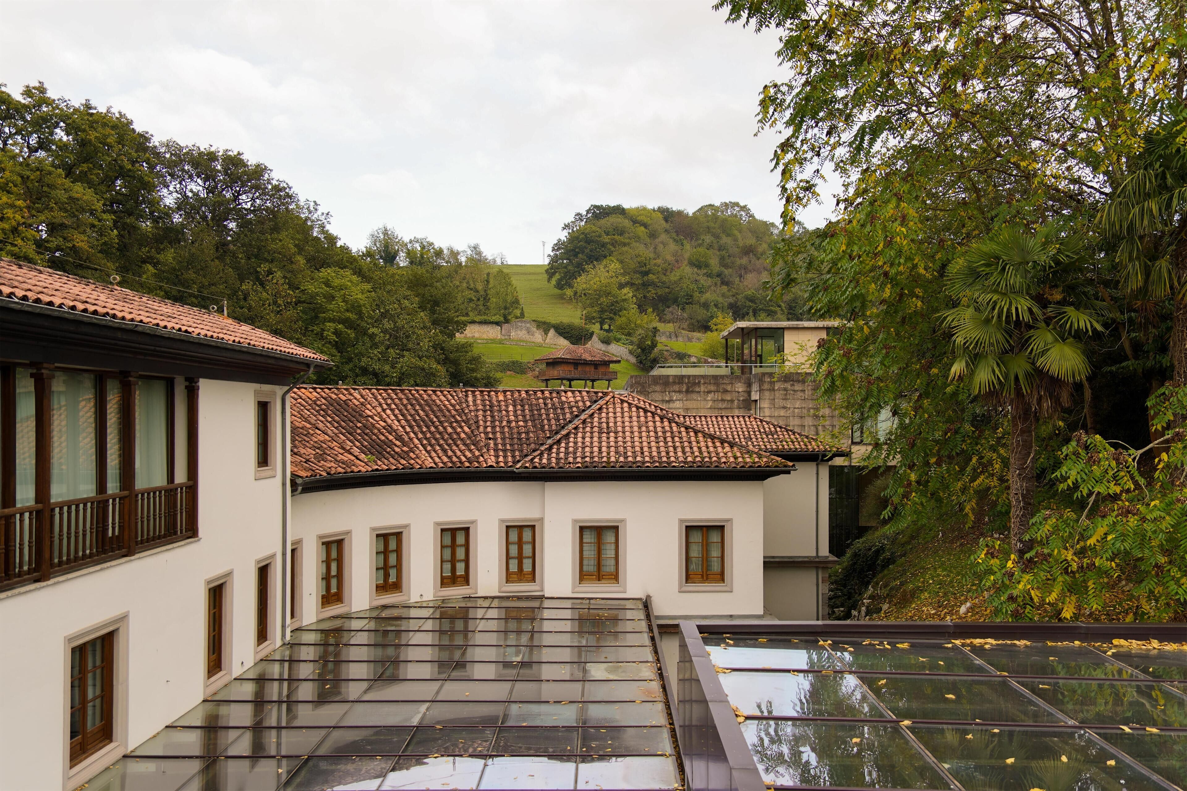 A building with a tiled roof, multiple windows, and a glass-covered terrace.
