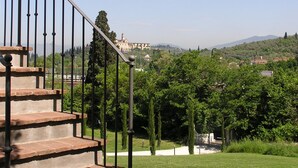 Una escalera que lleva a un edificio con vistas a un pueblo y colinas al fondo.