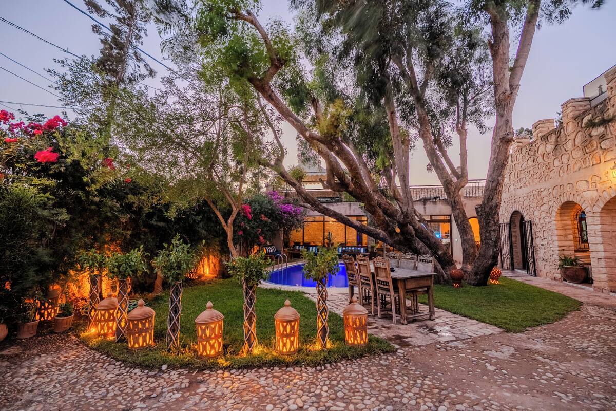 A courtyard with a pool, outdoor seating, and decorative lanterns.