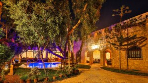 A courtyard with a swimming pool, stone walls, and potted plants. - Riad Dar Etto (Essaouira)