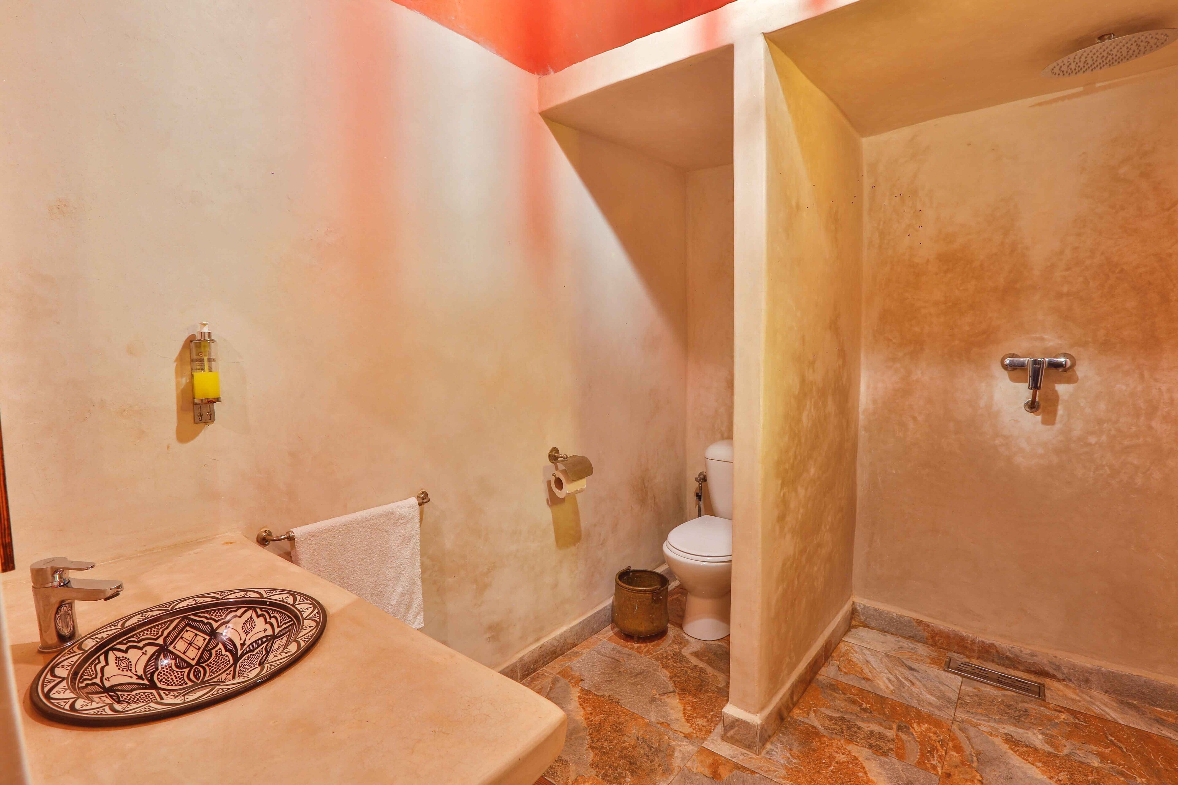 A bathroom with a sink, toilet, and shower.