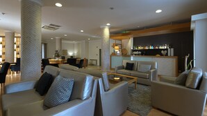 Un'area living moderna con divani, un tavolino e un angolo bar con bottiglie.