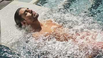 Una persona en un jacuzzi, con agua salpicando a su alrededor.