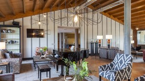 A spacious living area with a grand piano, modern furniture, and a unique ceiling design. - ARTIEM Asturias (Villaviciosa)