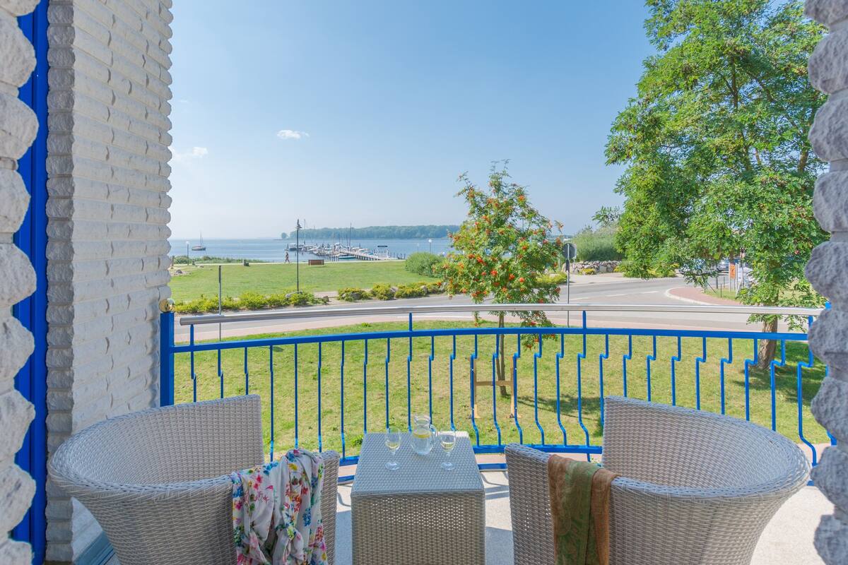 A balcony with wicker furniture and a view of the sea.