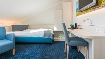 Une chambre d’hôtel moderne équipée d’un lit, d’un bureau, d’une chaise et d’un téléviseur.