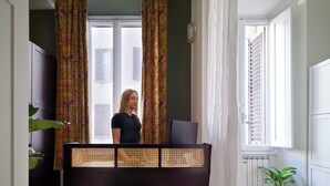 Une pièce avec un piano, une chaise, une plante en pot et une fenêtre avec des volets.