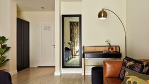 Un salon comprenant un canapé, une table basse, une lampe et une porte donnant sur une autre pièce.