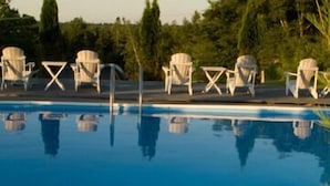 A pool area with lounge chairs and a flower in the foreground.