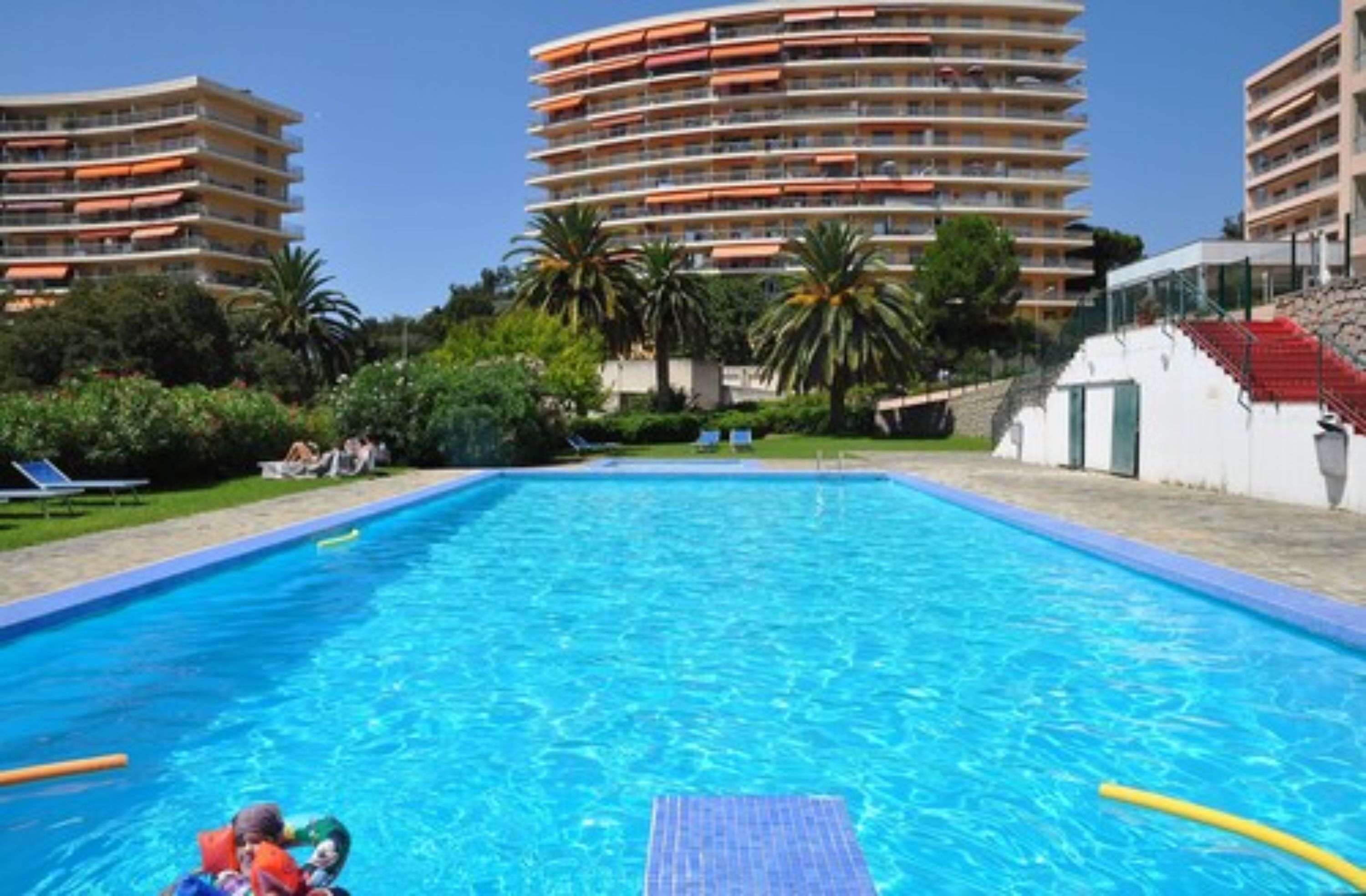 Una piscina al aire libre, tumbonas