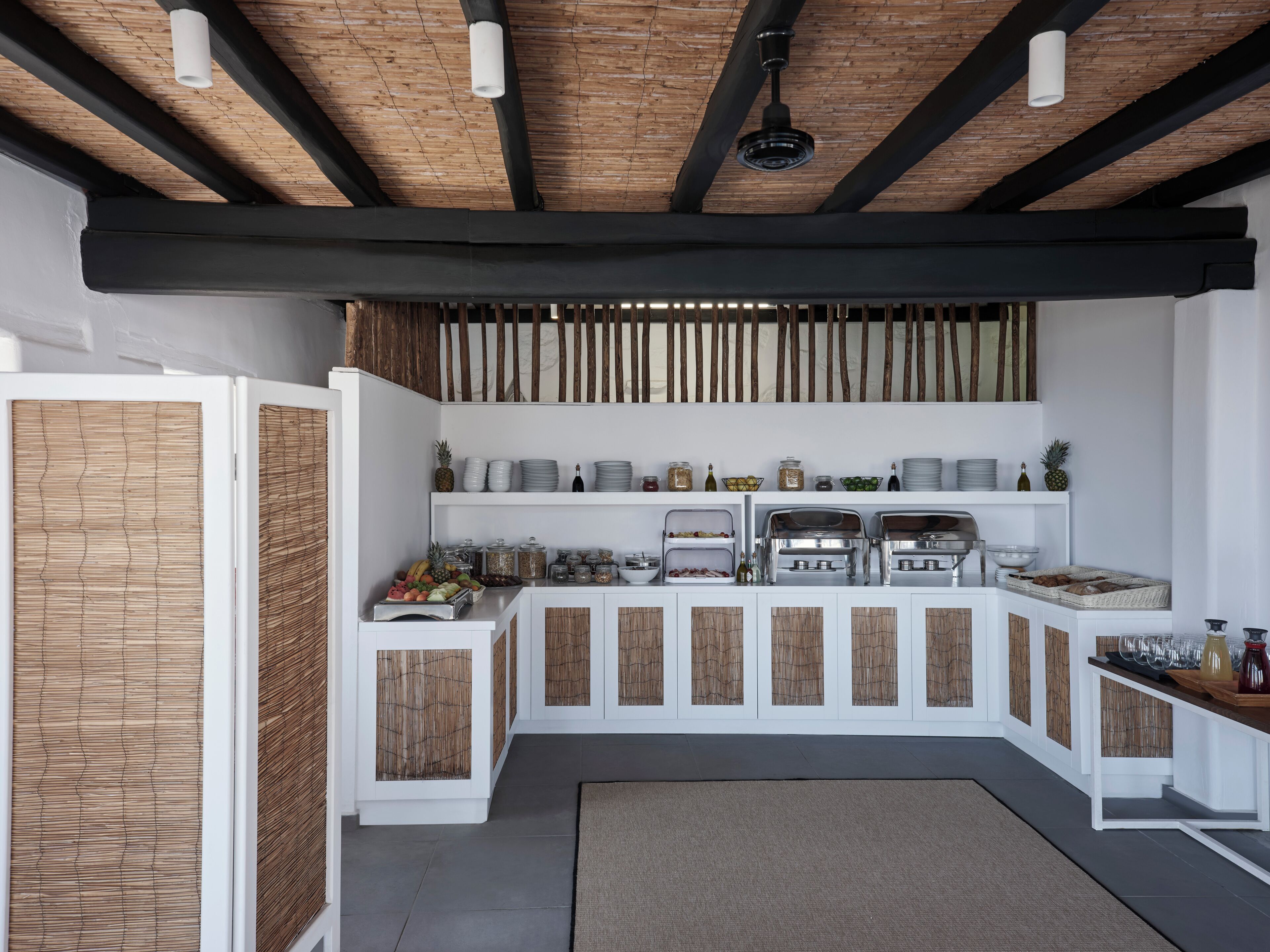 Une cuisine moderne dotée d’un îlot central intégré, de meubles blancs et d’une cloison décorée d’un motif en bambou.