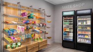 Un negozio di camere con scaffali pieni di snack, bevande e prodotti confezionati.