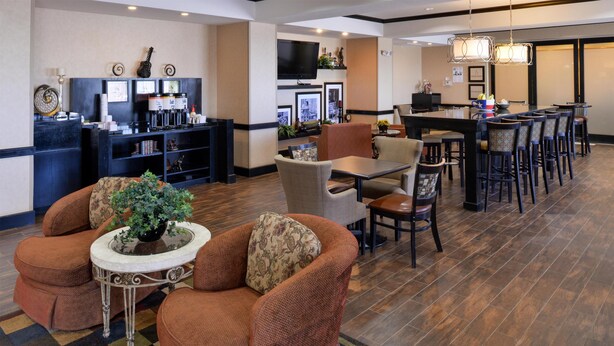 A hotel lobby with a bar area, seating, and a television. - Hampton Inn Pecos (Pecos)