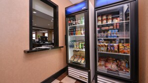 A hotel corridor with two refrigerated display cases containing beverages and snacks. - Hampton Inn Pecos (Pecos)
