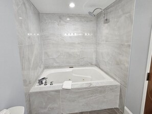 Uma casa de banho moderna com uma banheira independente, um chuveiro e uma sanita.