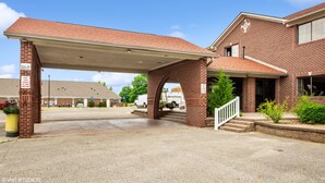 A brick building with a covered parking area and a staircase leading to the entrance. - My Hometown Inn (Mooresville)