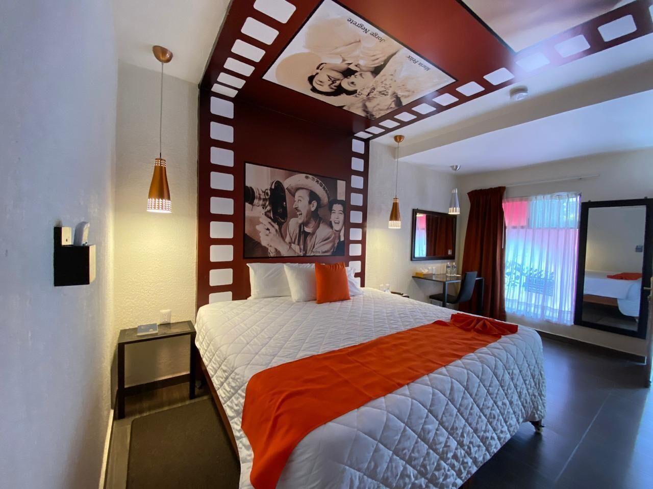 Una habitación de hotel con una cama grande, una mesita de noche, un escritorio y un baño con bañera.