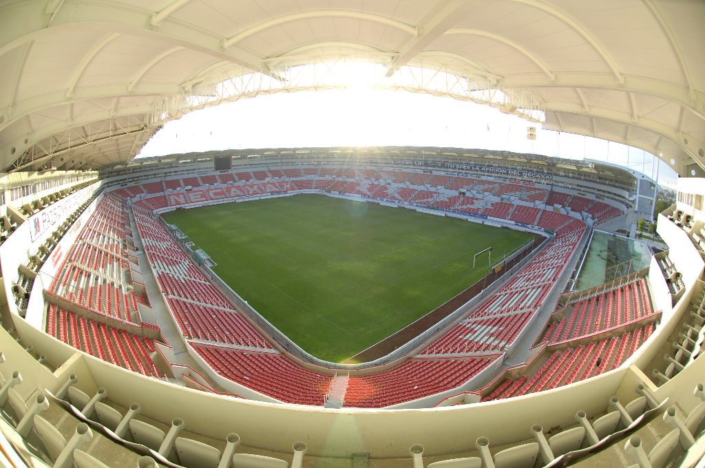 Un estadio con asientos en niveles escalonados, un campo central y una gran estructura de techo curva.