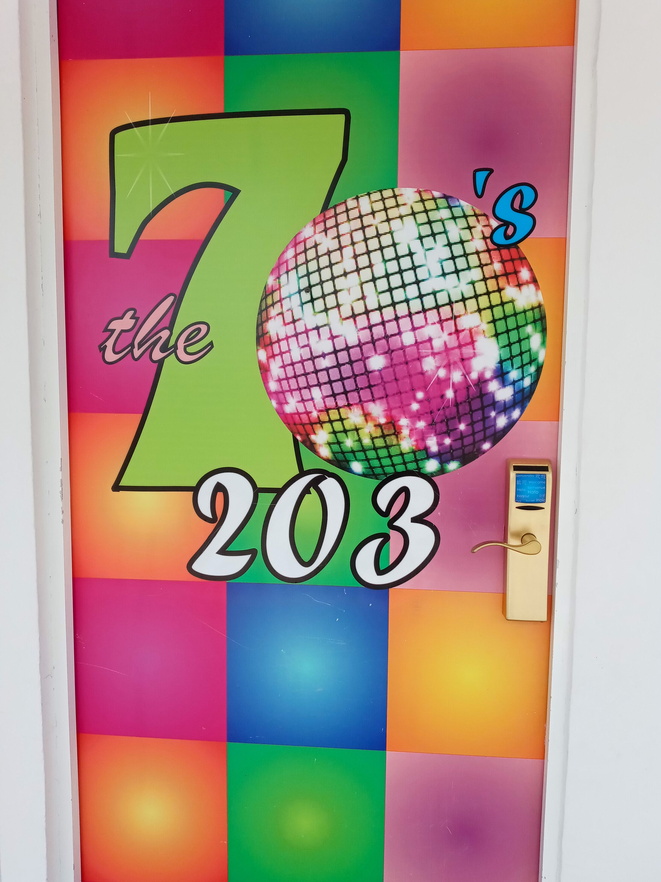 A door with a colorful design featuring the number 203 and a disco ball.