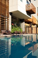 Una piscina al aire libre, sillones reclinables de piscina