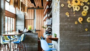 Un intérieur moderne avec un bar, un plafond en bois et un mur décoré de motifs de tournesols.
