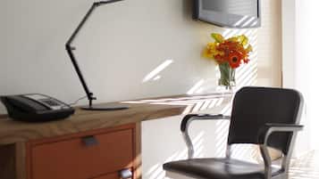 A modern office space with a desk, chair, and a mounted television.