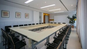 A conference room with a long table, black chairs, and recessed ceiling lights. - Jinjiang Inn Changchun Exhibition Center (Changchun)