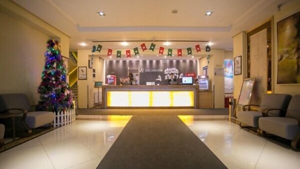 A hotel reception area with a Christmas tree, a reception desk, and seating on either side. - Jinjiang Inn Changchun Exhibition Center (Changchun)