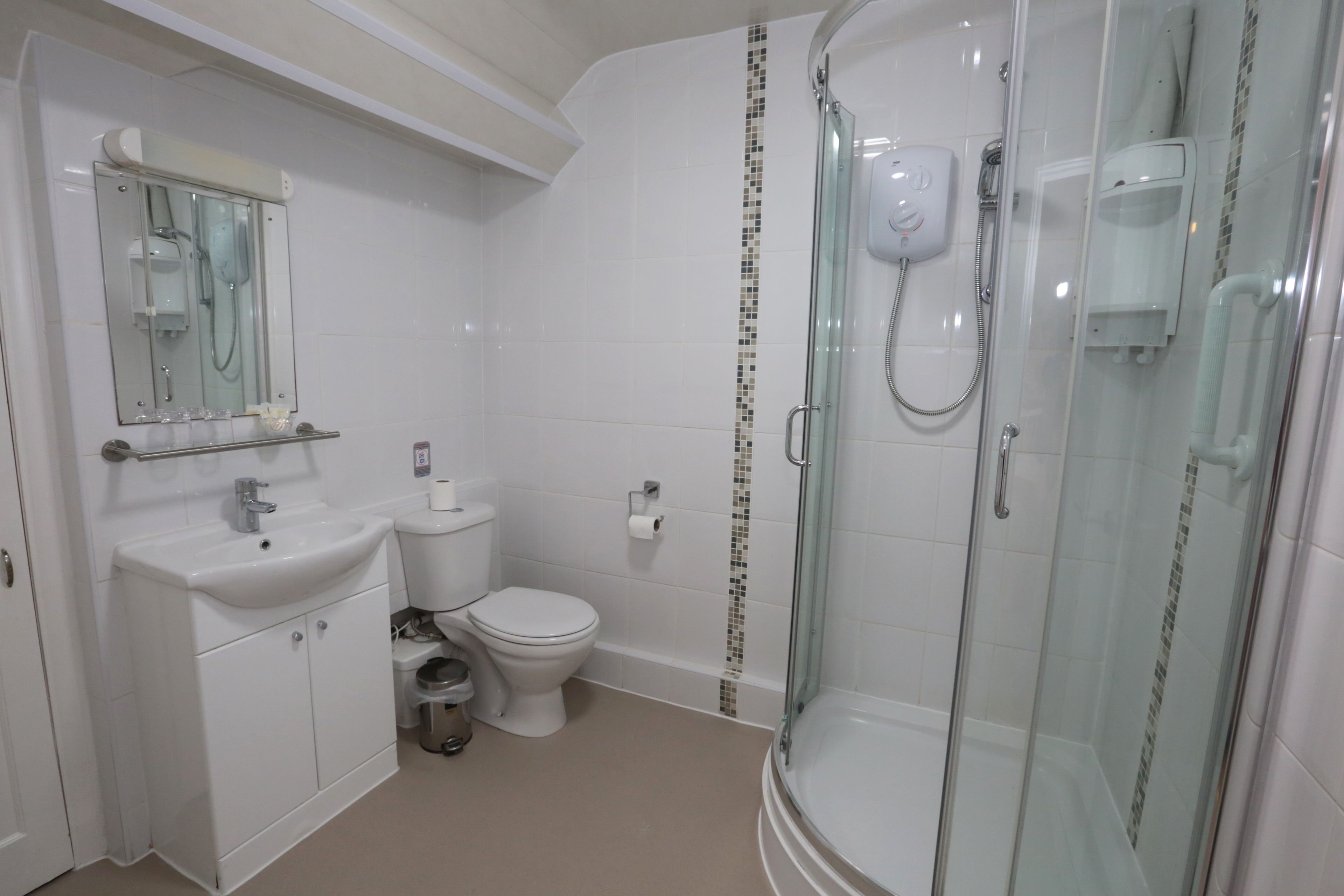A modern bathroom with a glass-enclosed shower, a white sink, and a toilet.