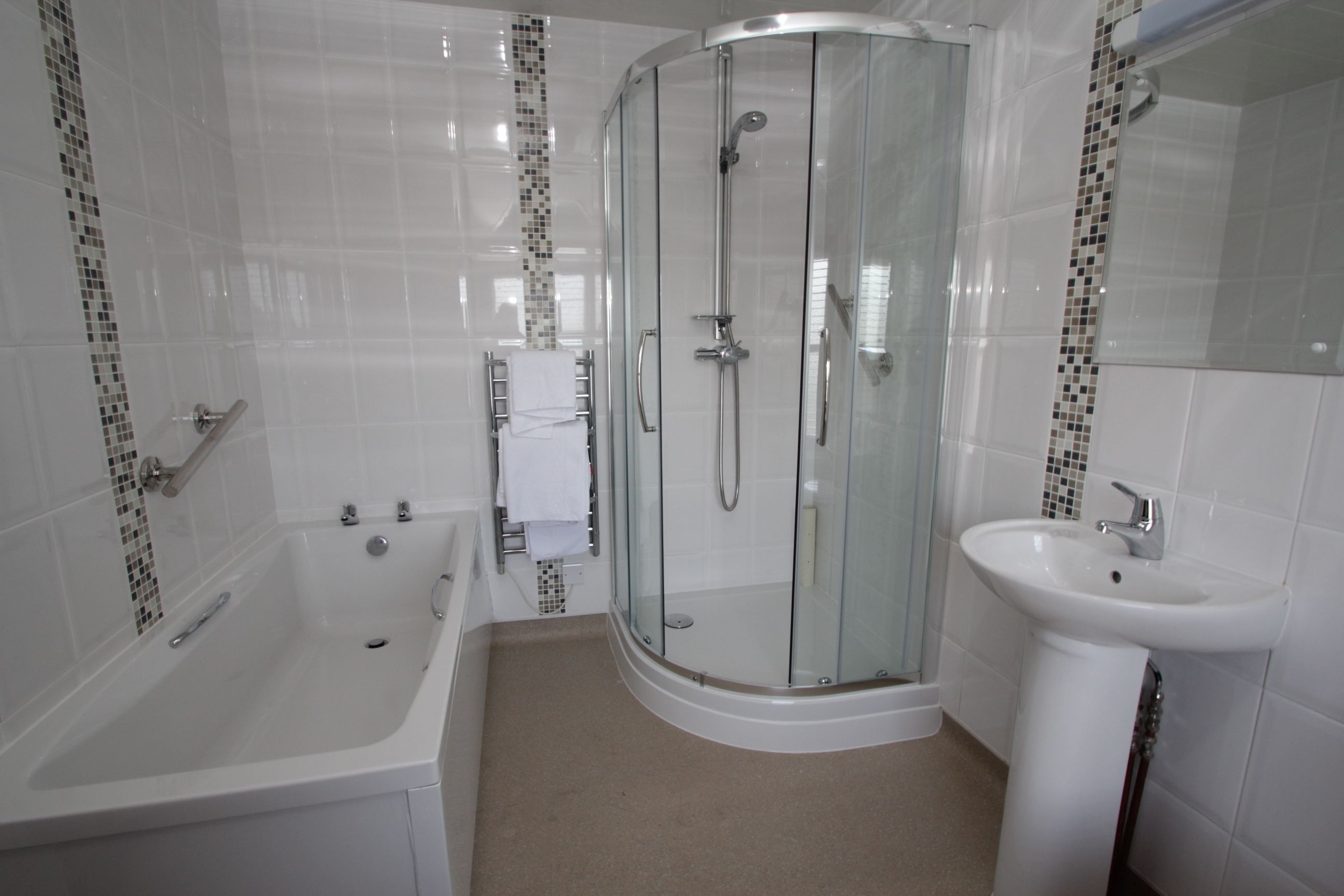 A modern bathroom with a glass-enclosed shower, a bathtub, and a sink.