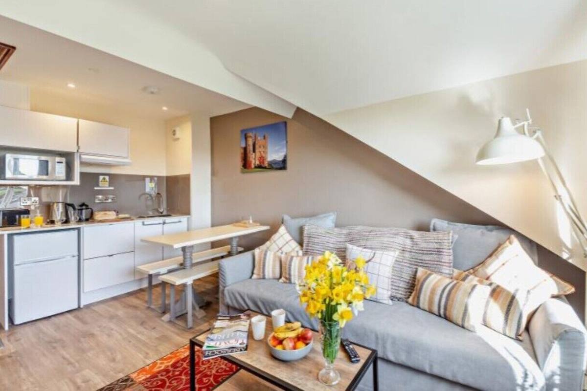 Ein modernes Apartment mit Küche, Essbereich und Wohnzimmer mit Sofa und Couchtisch.