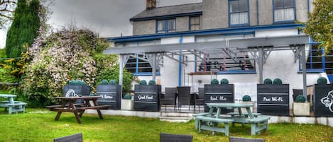 A building with a sign reading "Lion House" and outdoor seating with tables and chairs.