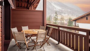A wooden deck with a table and chairs, overlooking a mountainous landscape. - Dormio Resort Les Portes du Mont Blanc (Vallorcine)