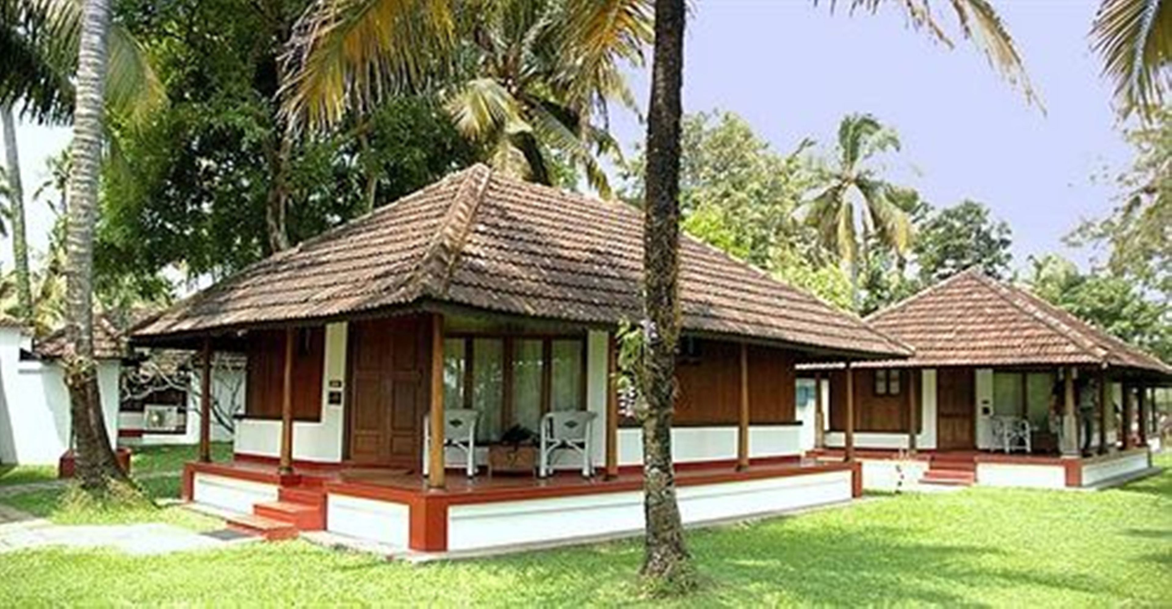 A bungalow-style hotel with a thatched roof, wooden exterior, and a small porch area.