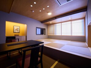A traditional Japanese room with tatami flooring, a low table, a television, and a shoji screen. - Gion Shinmonso (Kyoto)