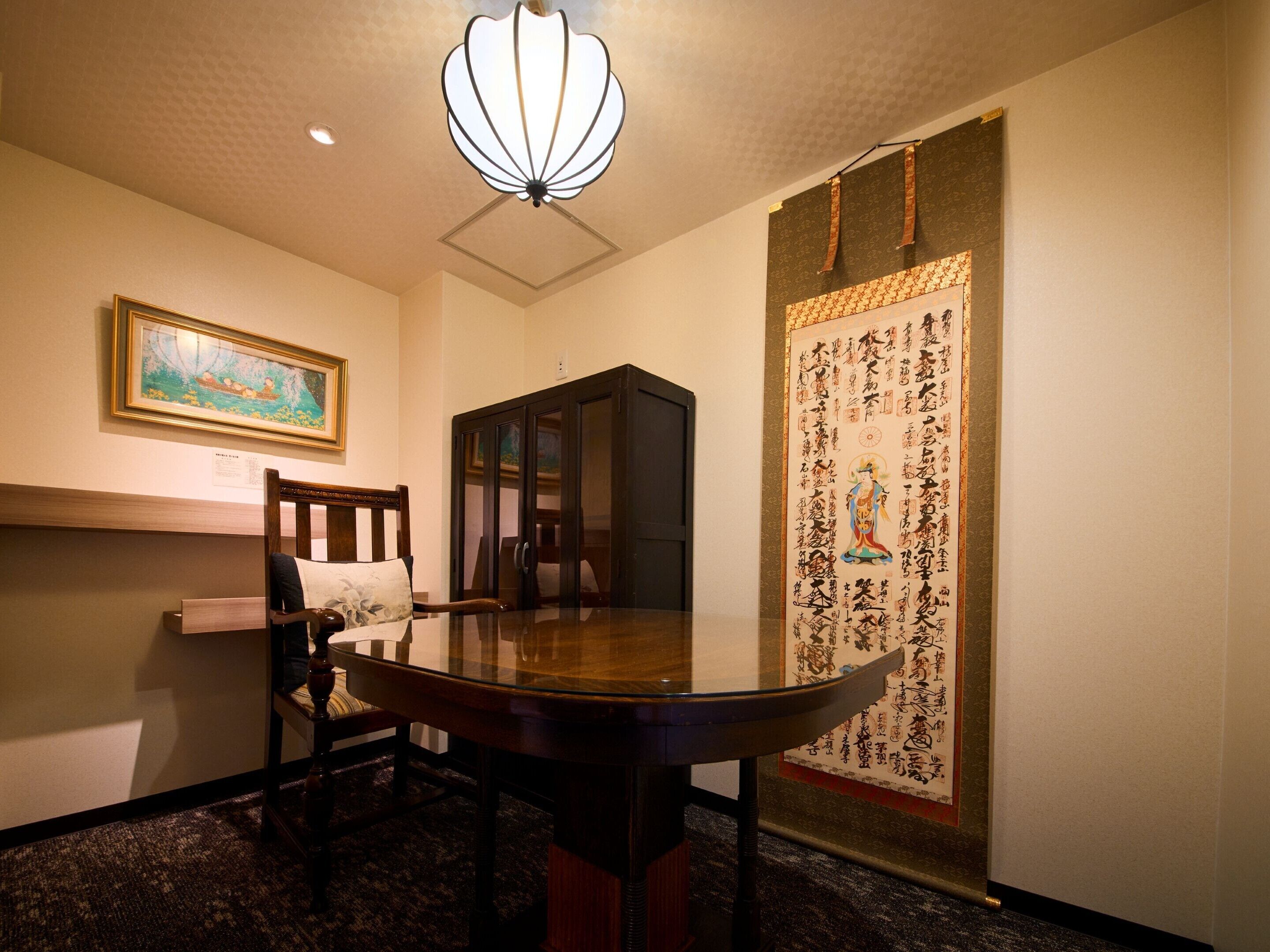 Una habitación japonesa tradicional con suelo de estera de tatami, una mesa de madera baja, una silla de madera oscura, un farol colgante y una puerta corredera con caligrafía.