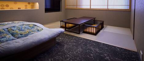 A room with a bed, a table, and a TV.