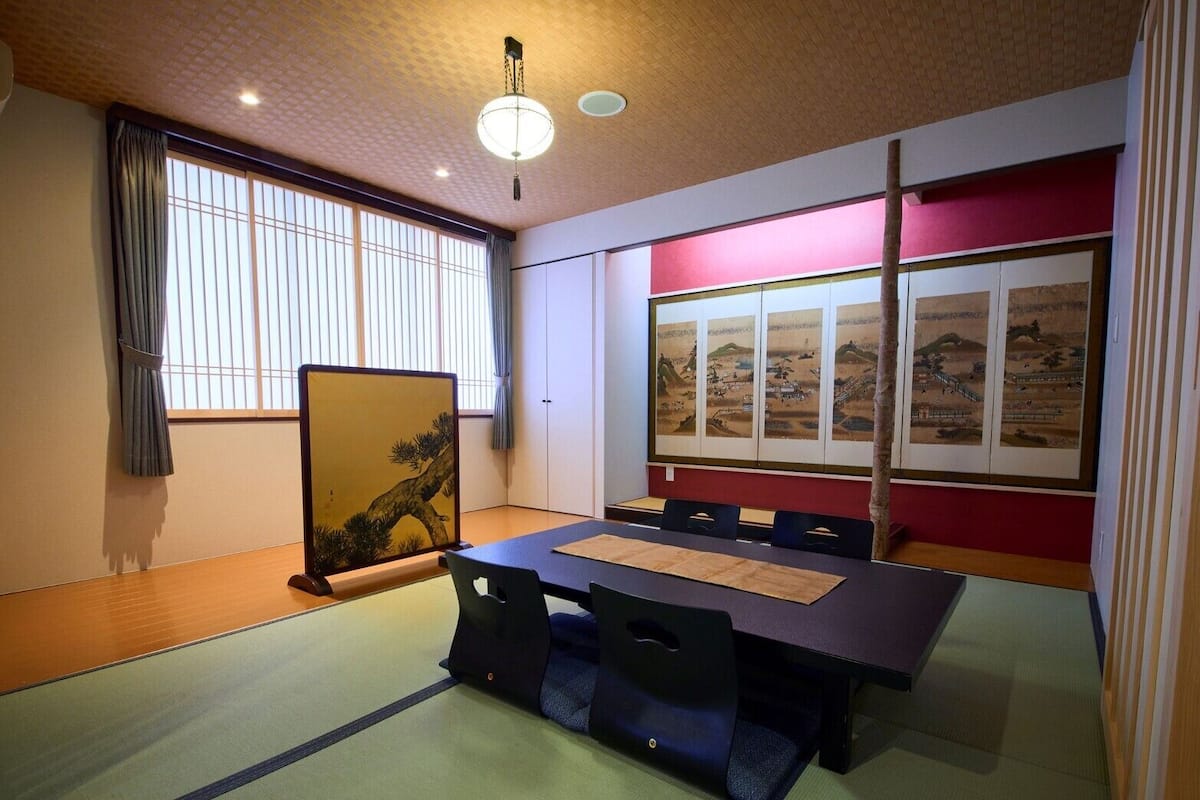 Een traditionele Japanse kamer met tatami vloerbedekking, een lage tafel en shoji schermen.