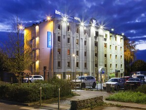 En moderne hotelbygning med skilt for 'ibis budget hotel'.