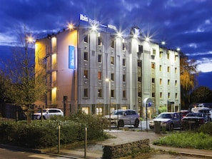Un bâtiment d’hôtel moderne avec une enseigne indiquant « ibis budget hotel ».