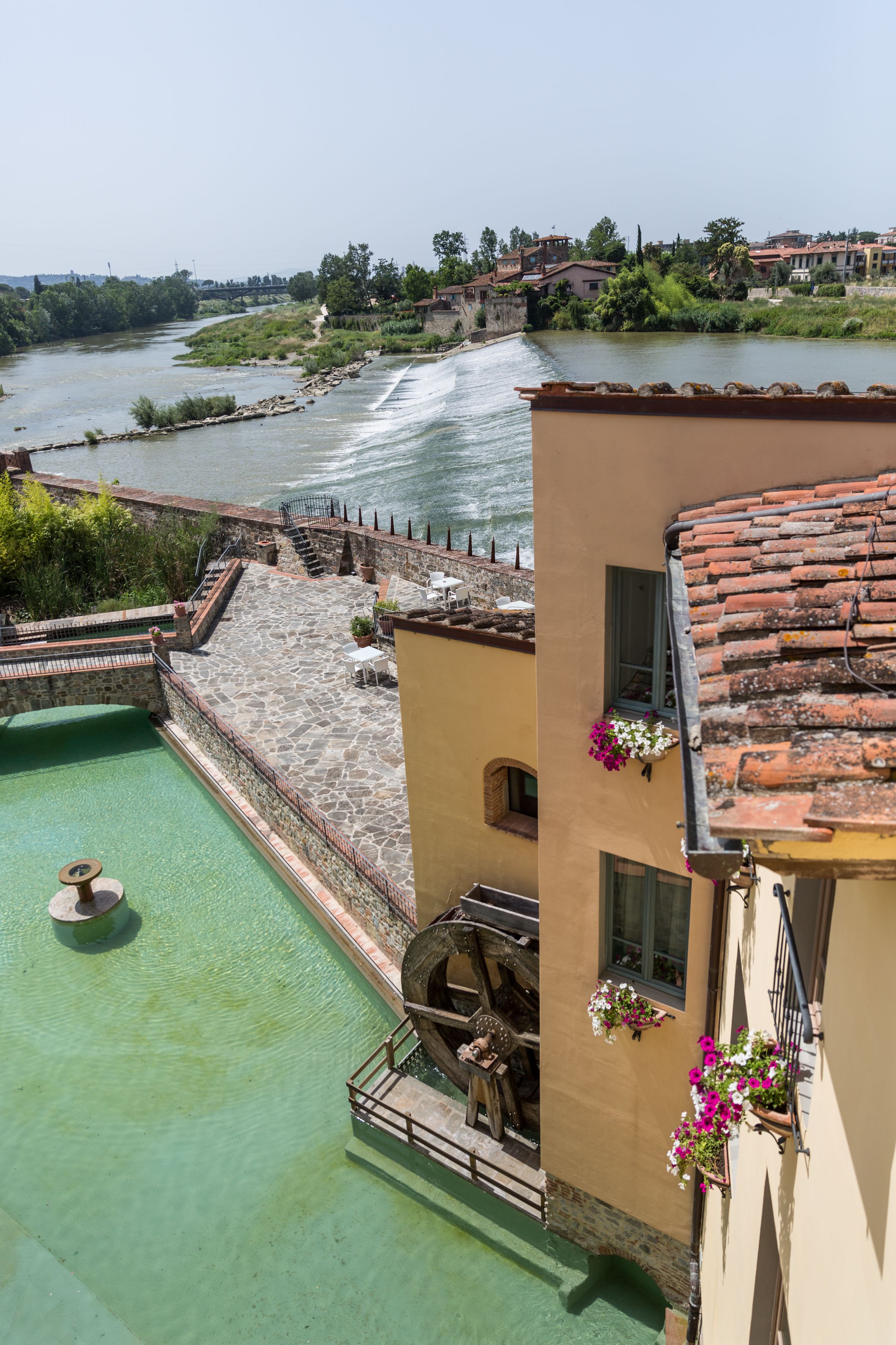 Una piscina en la azotea con vistas a un río y edificios circundantes.
