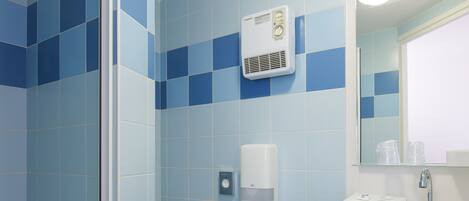 A bathroom with blue tiles, a white sink, a mirror, and a towel rack.