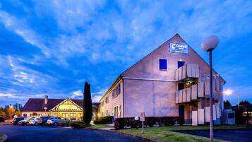 A Comfort Hotel with a restaurant, parking area, and a unique architectural design.