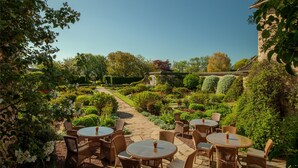 A garden patio with wicker furniture and a stone pathway.