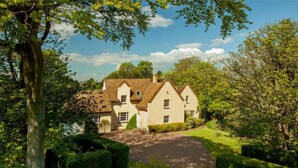 A traditional house with a well-maintained garden, a paved driveway, and a clear sky. - Greywalls Hotel and Chez Roux (Gullane)
