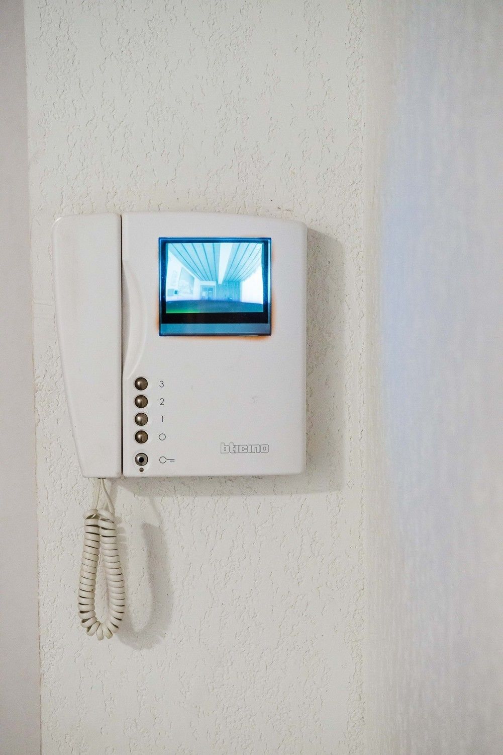 Un teléfono de pared con una pantalla que muestra el interior de un edificio.