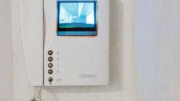 A wall-mounted telephone with a screen displaying a building's interior.