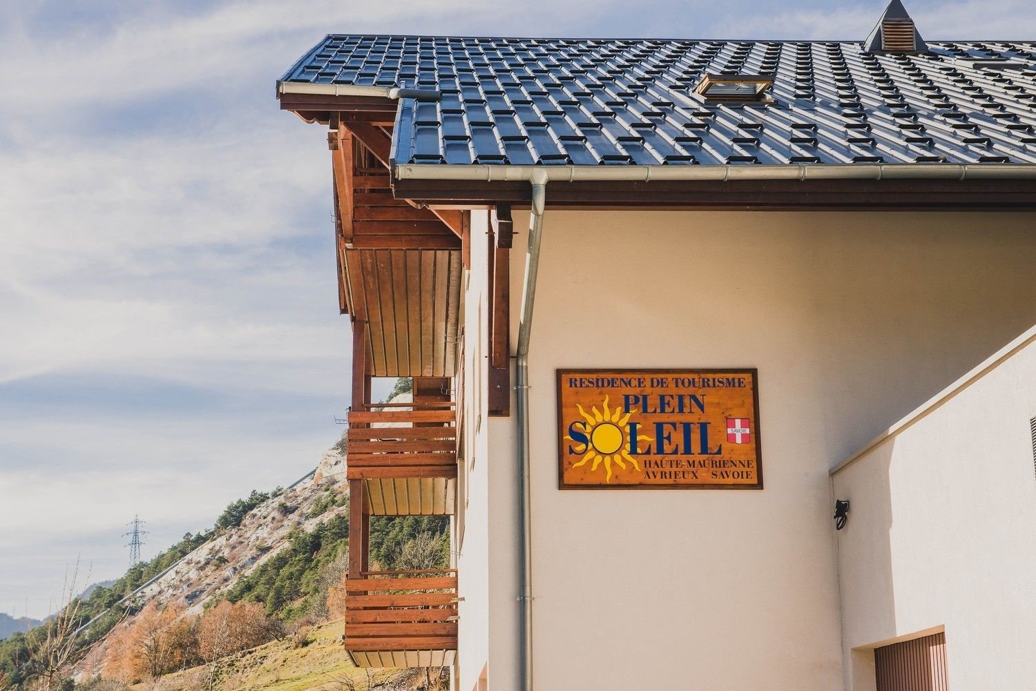 En bygning med skilt, der angiver at det er et "Residence de Tourisme Plein Soleil" i Haute-Maurienne, Avrières, Savoie.