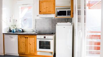 A modern kitchen with wooden cabinets, a dishwasher, an oven, and a microwave.