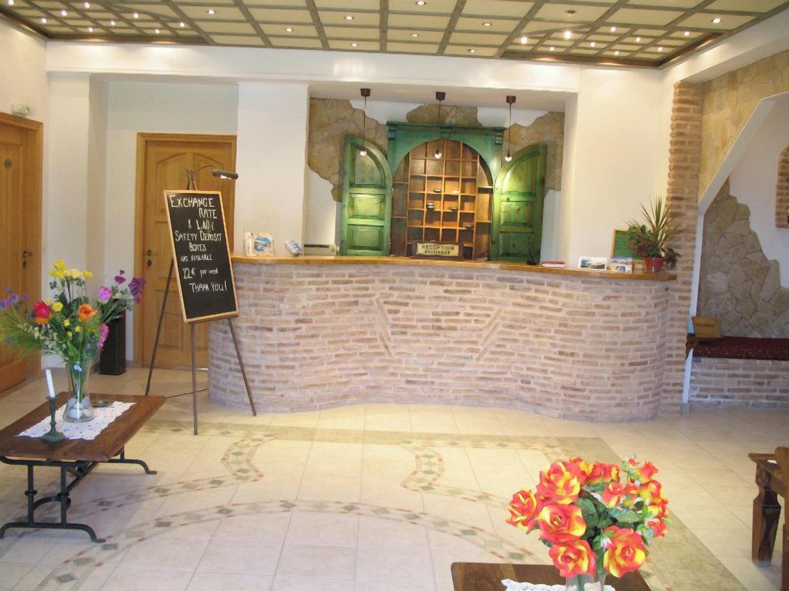A reception area with a brick counter, a chalkboard sign, and a floral arrangement.